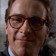 Un homme qui porte des lunettes cerclées sourit.