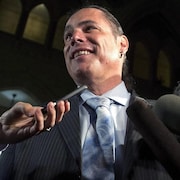 Patrick Brazeau est entouré de micros au Sénat.