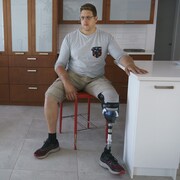 Portrait de Paul-André Perreault avec sa prothèse dans sa cuisine