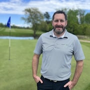 Un homme devant un terrain de golf.