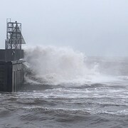 Cette vague vient se fracasser sur le coin du quai.