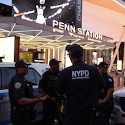 Des policiers discutent devant l'entrée de la gare.