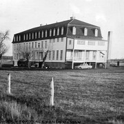 Une vieille photo en noir et blanc montre le bâtiment de trois étages. 