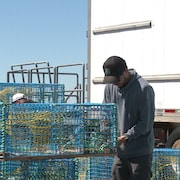 Un pêcheur innu prépare une cage de homard. 