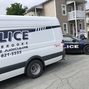 Le camion de l'identité judiciaire de Service de police de Sherbrooke devant un duplex de Magog.