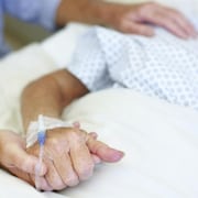 Une personne âgée sur un lit d'hôpital.