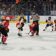 Un arbitre procède à une mise au jeu lors d'un match disputé dans le cadre du 58e Tournoi international de hockey pee-wee en 2017.