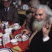 Des aînés mangent un repas de Noël assis à une table. 