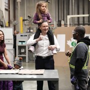 Pierre Poilievre, avec sa fille sur ses épaules, discute avec un travailleur.