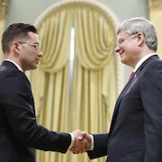 Le premier ministre canadien Stephen Harper serre la main du ministre d'État chargé de la réforme démocratique, Pierre Poilievre, après l'assermentation de ce dernier lors d'une cérémonie à Rideau Hall, à Ottawa.