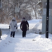 Deux personnes marchent dehors l'hiver.