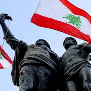 Des drapeaux libanais et un noeud coulant accrochés à une statue.