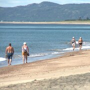 Des résidents et des touristes marchent sur la plage de Val-Marguerite, à Sept-Îles.