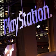 Le logo de PlayStation est illuminé a l'extérieur d'un édifice.