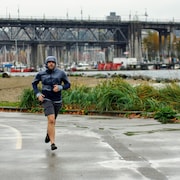 Un homme entrain de courir sous la pluie.