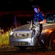 Un policier armé dans la nuit.