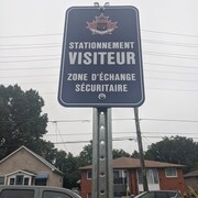 Un panneau de la police de North Bay indique "stationnement visiteur. Zone d'échange sécuritaire".