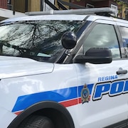 Un véhicule de la police de Regina est garé devant un immeuble.