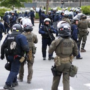 Des dizaines de policiers antiémeutes marchent à proximité des fortifications du Vieux-Québec.
