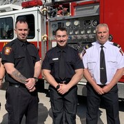 Les quatre pompiers devant un camion.