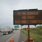 Un panneau près de l'autoroute signalant la fermeture de celle-ci au pont de l'île-aux-Tourtes.  