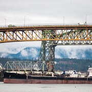 Un gros navire est sur la rivière Fraser en dessous du pont Ironworkers Memorial. 