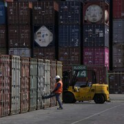 Un travailleur portuaire ferme un conteneur après une inspection dans le port de Manzanillo, au Mexique, le mercredi 19 juillet 2023.