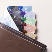 Des billets de banque canadiens dans un portefeuille de cuir brun. 
