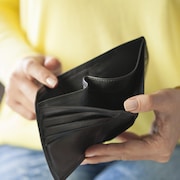 Une personne tient dans ses mains un portefeuille vide. 