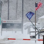 Drapeaux des États-Unis et de Donald Trump à un poste frontalier. 
