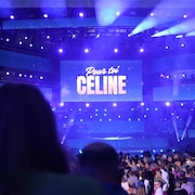 Un écran géant au centre de la scène avec l'inscription « Pour toi Céline ».
