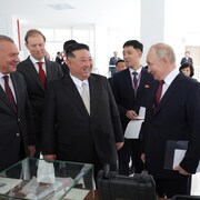 Vladimir Poutine et Kim Kong-un entourés de dignitaires lors d'une visite.