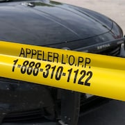 Une voiture de la Police provinciale de l'Ontario avec un bandeau devant indiquant un numéro où appeler.