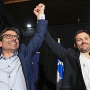 Le candidat Pascal Paradis lève son bras avec le chef du parti Paul St-Pierre Plamondon avant de prendre la parole devant les partisans.