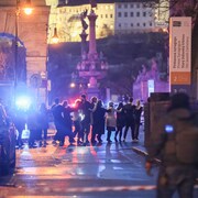 Des étudiants marchent en se tenant par les épaules dans la rue. 