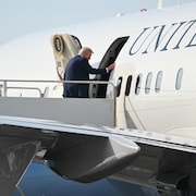 Donald Trump monte à bord d'un avion.