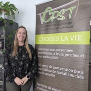 Anabelle Landry-Genesse, directrice générale du Centre de prévention du suicide du Témiscamingue, se tient devant une affiche de prévention du suicide. 