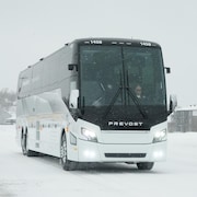 Un autocar sur la route en pleine tempête de neige.