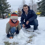 Un père et son fils jouent dans la neige.