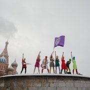 Les Pussy Riot cagoulées et brandissant un drapeau devant la cathédrale Christ-Sauveur de Moscou.