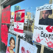 Des affiches collées aux vitres du quartier général du Service de police de Winnipeg.