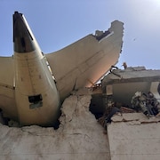 La queue d'un avion encastr&eacute; dans un immeuble.