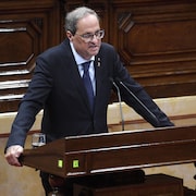 Quim Torra se tient derrière un lutrin et prend la parole au Parlement à Barcelone, le 17 octobre 2019. 