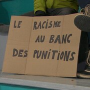 Une pancarte qui dénonce le racisme dans les arénas, au match antiracisme de Gesgapegiag.