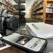Un appareil photo, un carnet de notes et un téléphone portable sur une table, dans la Bibliothèque de Sainte-Anne, le 6 janvier 2023.