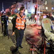 Un secouriste transporte une femme sur son dos.