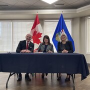 (De droite à gauche) Patty Hajdu, ministre des Services aux Autochtones du Canada,  Randy Boissonnault,  ministre de l’Emploi et des Langues officielles et Adrianna Lagrange, ministre de la Santé de l’Alberta, assis à une table.