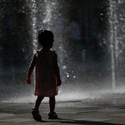 Un enfant passe dans des jets d'eau.