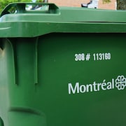 Un bac de recyclage en gros plan et, en arrière-plan, un camion de recyclage.