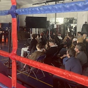 Les participants qui écoutent la formation au club de boxe.